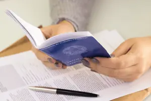 Mãos segurando carteira de trabalho.